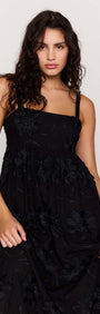 Black Tiered Cotton Applique Midi Dress featuring elegant floral detailing and a flowing silhouette.