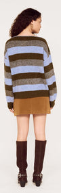 Back view of a model wearing a Blue Stripe Soft Boat Neck Jumper paired with a brown skirt and knee-high boots.