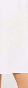 Close-up of Broderie Anglaise Cotton Mini Dress featuring beige floral embroidery on a white fabric.