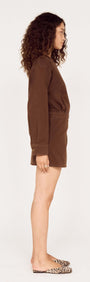 Model showcasing the Brown Denim Wrap Mini Dress from the side, featuring a modern and stylish design.
