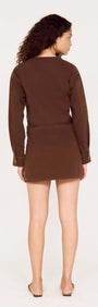Back view of a model wearing a Brown Denim Wrap Mini Dress, showcasing the style and fit.