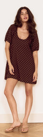Brown Linen Blend Polka Dot Puff Sleeve Mini Dress model showcasing a chic, casual style with puff sleeves and polka dots.