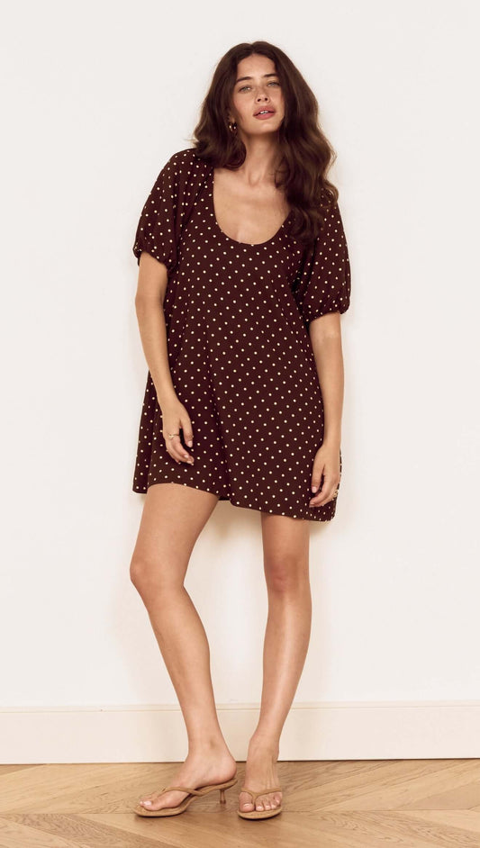 Brown Linen Blend Polka Dot Puff Sleeve Mini Dress model showcasing a chic, casual style with puff sleeves and polka dots.