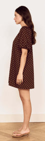 Model in the Brown Linen Blend Polka Dot Puff Sleeve Mini Dress, showcasing a chic brown and cream polka dot design.