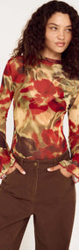 Model wearing a Red Floral Sheer Mesh High Neck Top with bell sleeves and brown pants.