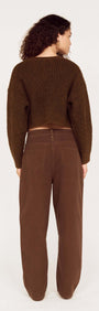 Back view of a model wearing a Brown Cropped Cardigan with Gold Button Detail, styled with matching brown pants.