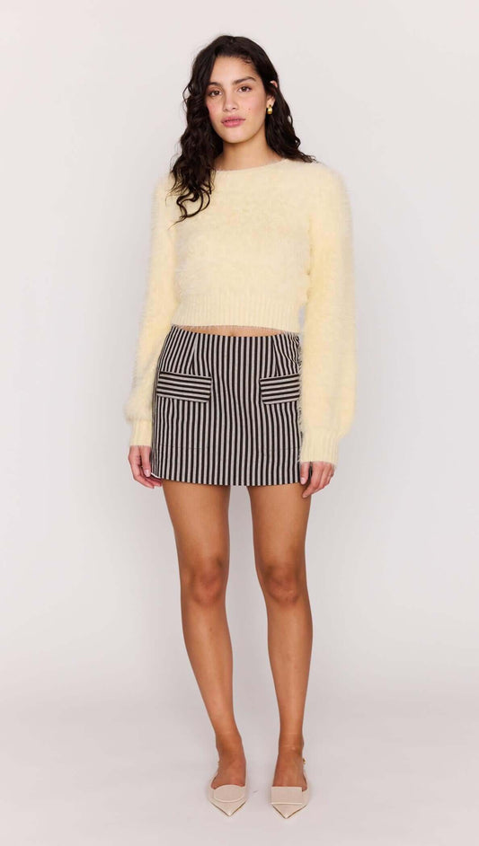 Model wearing a Butter Yellow Fluffy Knit Jumper paired with a striped skirt, showcasing a chic, relaxed look.