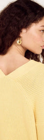 Butter Yellow Oversized Cardigan with Volume Sleeve shown on a model from the back, highlighting the soft knit and sleeve details.