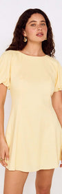 Butter Yellow Puff Sleeve Mini Dress displayed by a model with curly hair, showcasing a soft and feminine style.