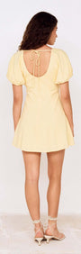 Butter Yellow Puff Sleeve Mini Dress showcasing the back view with a tie detail and a flared skirt.