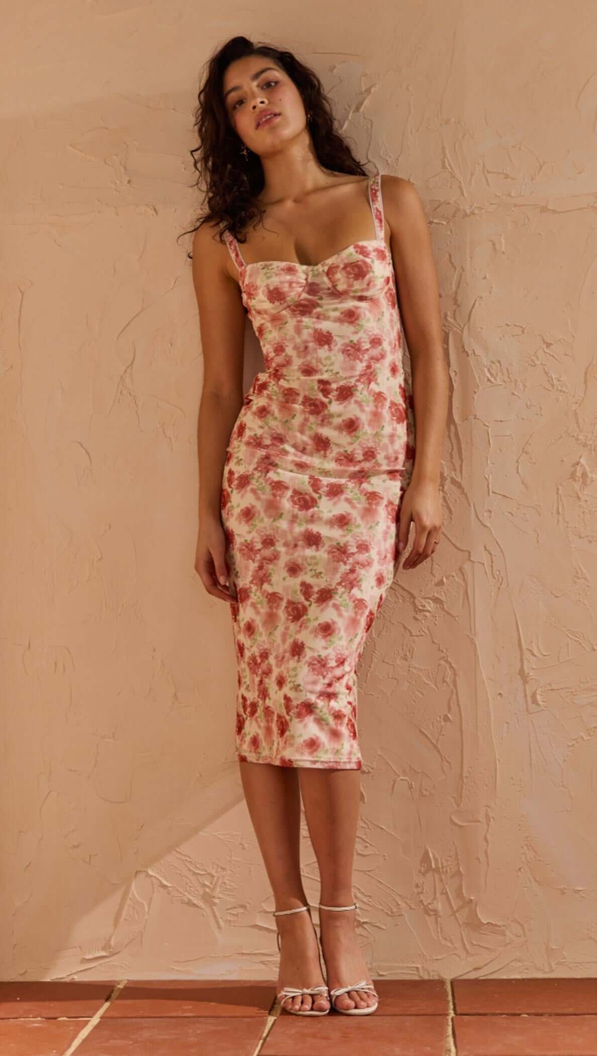 Pink Floral Bustier Mesh Midi Dress on model against textured wall, showcasing floral design and fitted silhouette.