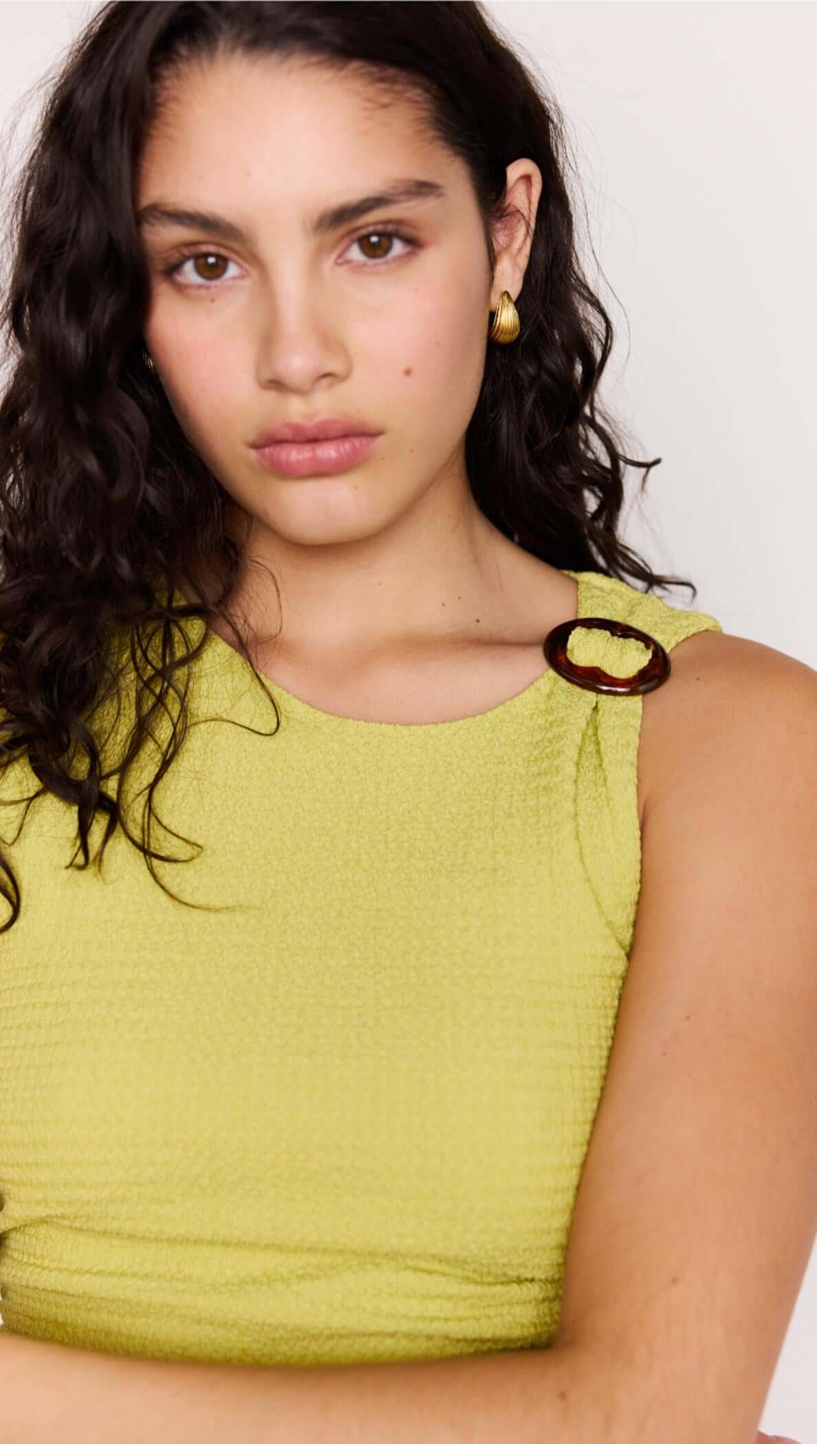 Model wearing a Chartreuse Ruched Mini Dress featuring subtle shoulder ring detail and textured fabric.
