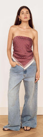 Model wearing Chocolate Polka Dot Scarf as a bandeau top with wide-leg jeans.