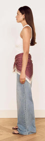 Woman wearing a Chocolate Polka Dot Scarf tied as a waist scarf, styled with relaxed denim jeans.