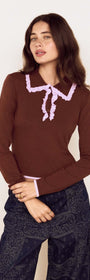 Model wearing a Chocolate Ruffle Collar Polo Knit Top with playfully contrasting ruffle trims and long sleeves.