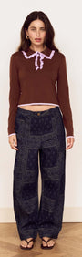 Model wearing the Chocolate Ruffle Collar Polo Knit Top with relaxed denim for a stylish look.