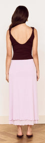 Back view of a model wearing the stylish Chocolate Twist Shoulder Mesh Top and a pastel pink skirt.