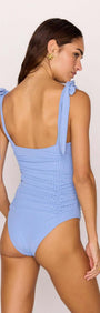 Back view of a woman wearing a Blue Ruched One Piece Swimsuit with self-tie shoulder straps and gathered ruching.