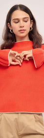 Aspen Coral Knit Top with Contrast Trim featuring flared cuffs and a relaxed fit.