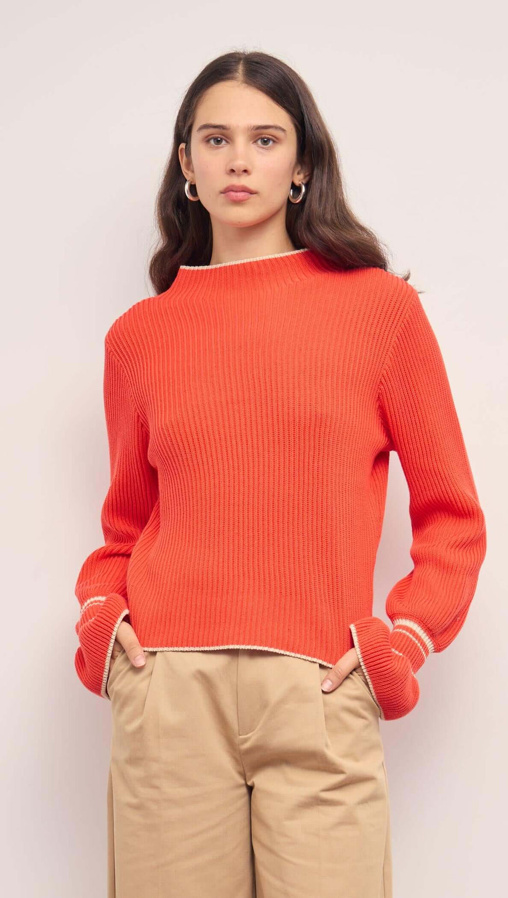 Coral Knit Top with Contrast Trim shown on a model, featuring flared cuffs and a relaxed fit.