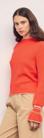 Coral Knit Top with Contrast Trim worn by a model, featuring ribbed knit and flared cuffs.
