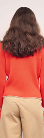 Back view of the Coral Knit Top with Contrast Trim, showcasing its soft ribbed fabric and flared cuffs.