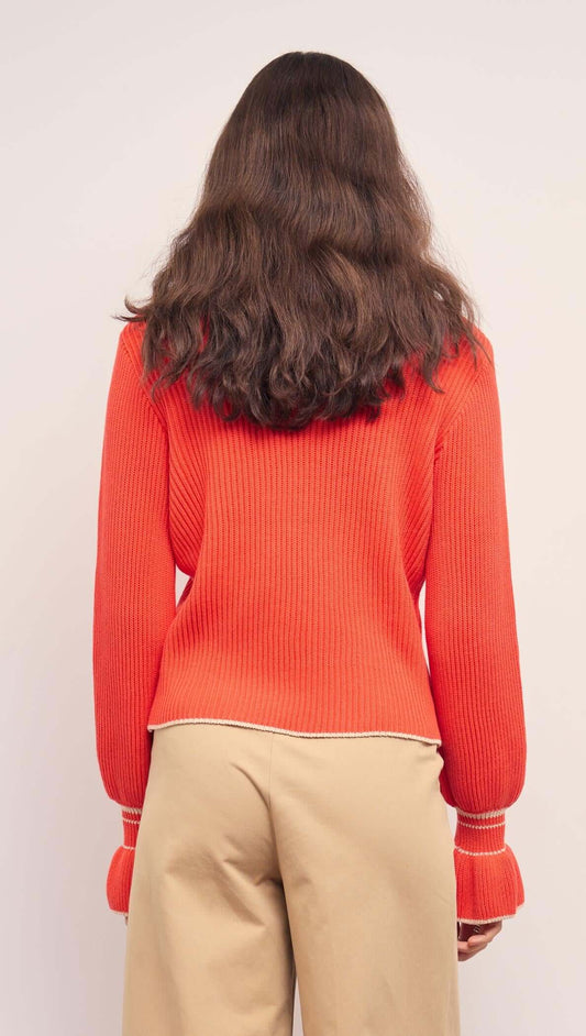 Back view of the Coral Knit Top with Contrast Trim, showcasing its soft ribbed fabric and flared cuffs.