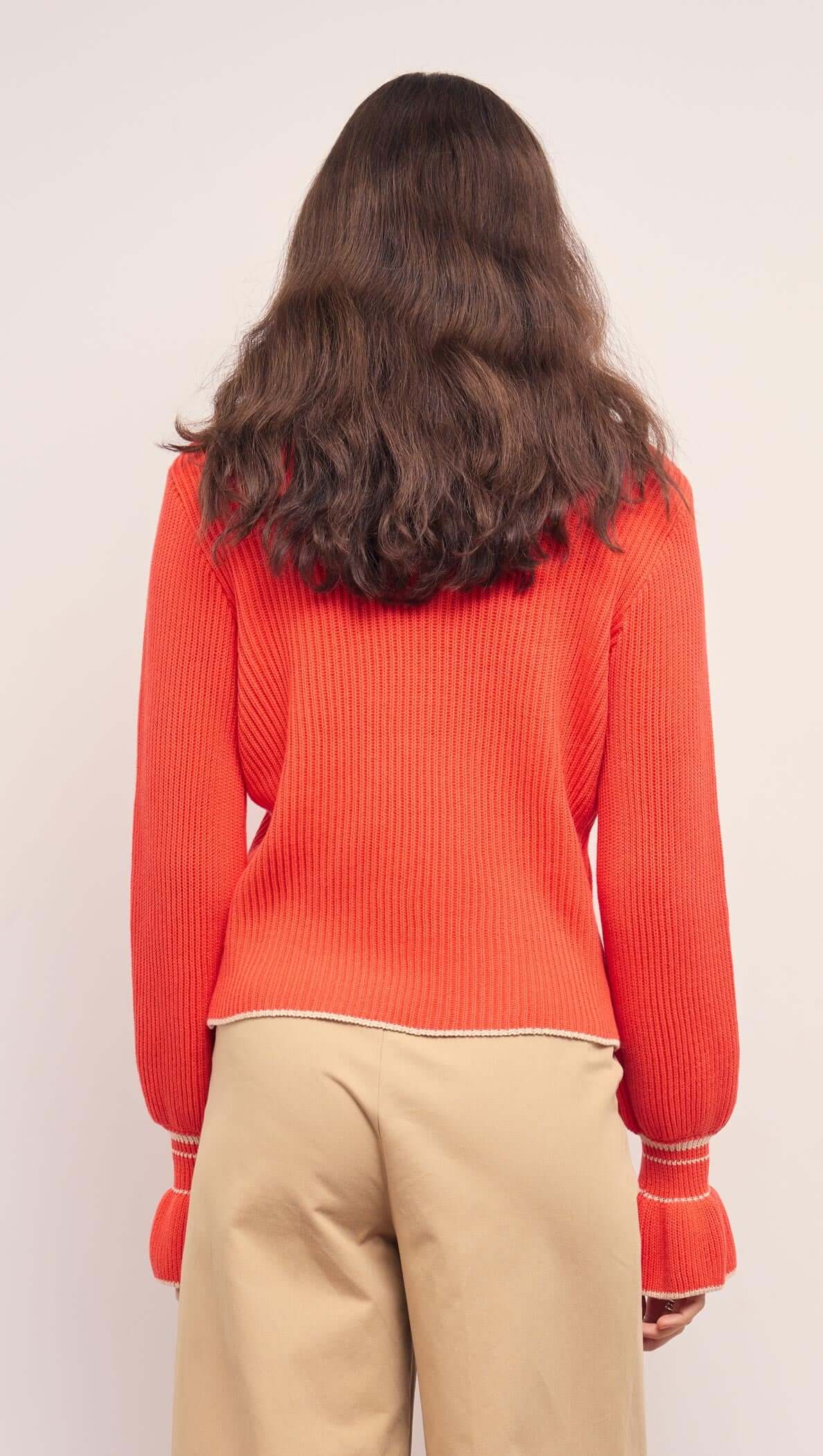 Back view of the Coral Knit Top with Contrast Trim, showcasing its soft ribbed fabric and flared cuffs.