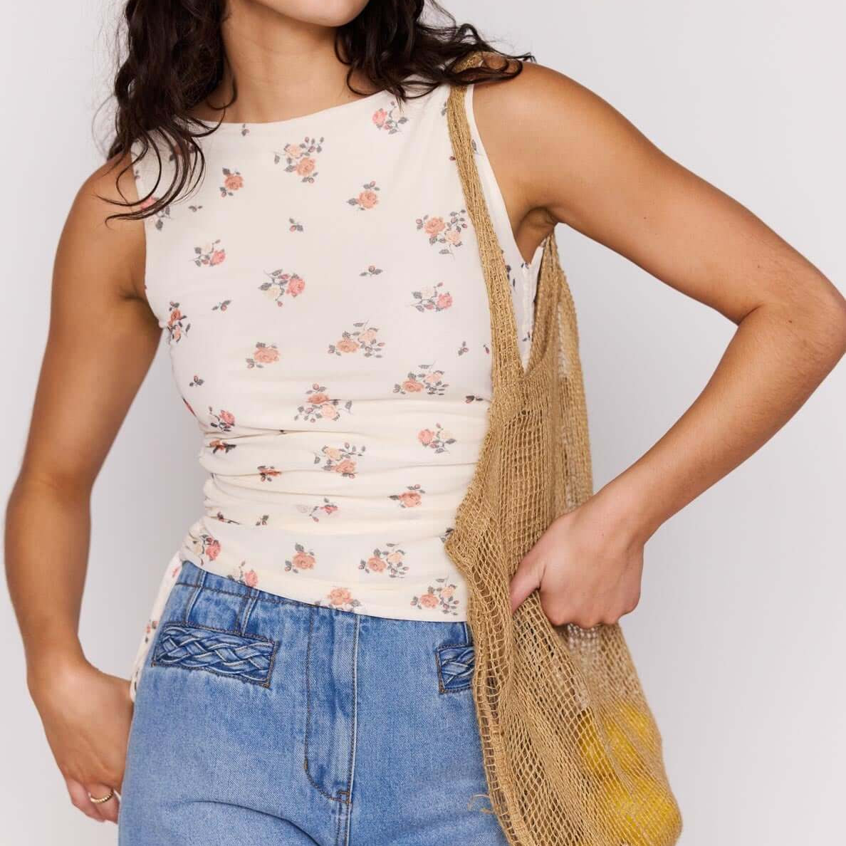Cream Floral Boat Neck Mesh Top worn by a woman, paired with denim shorts and a woven bag.