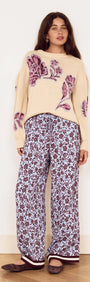 Model wearing the Cream Floral Intarsia Knit Sweater paired with floral print pants and cozy flats.