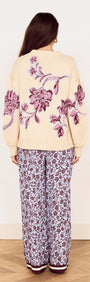 Back view of a model wearing the Cream Floral Intarsia Knit Sweater styled with floral print pants.