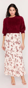 Model wearing a Cream Floral Toile Bias Cut Maxi Skirt paired with a burgundy sweater, showcasing a stylish and elegant outfit.