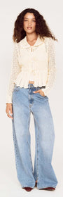 Model wearing a Cream Pointelle Knit Cardi with Tie Front styled with wide-leg jeans.