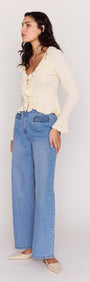 Model wearing a Cream Ruffled Cardigan with button-through front, paired with blue wide-leg jeans.