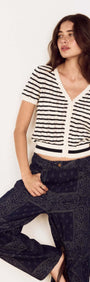Model wearing Cream Stripe Cotton Pointelle Knit Top with denim pants, showcasing a stylish layered look.