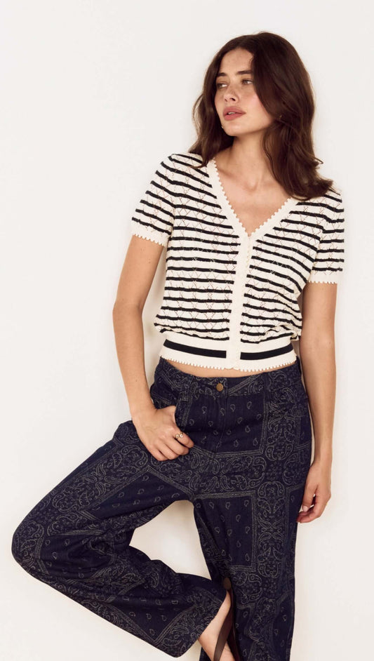 Model wearing Cream Stripe Cotton Pointelle Knit Top with denim pants, showcasing a stylish layered look.