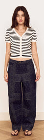 Model wearing the Cream Stripe Cotton Pointelle Knit Top with relaxed pants in a stylish pose.
