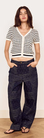 Model wearing the Cream Stripe Cotton Pointelle Knit Top with relaxed pants and sandals, showcasing an effortless look.