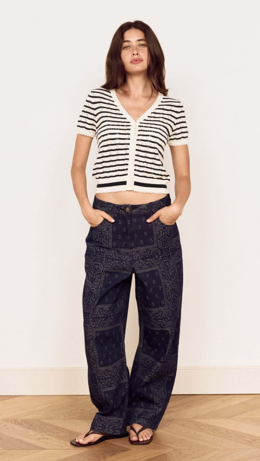 Model wearing the Cream Stripe Cotton Pointelle Knit Top with relaxed pants and sandals, showcasing an effortless look.