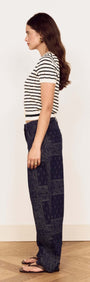 Model wearing Cream Stripe Cotton Pointelle Knit Top with denim pants, showcasing a stylish side profile.