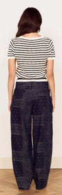 Back view of a woman wearing the Cream Stripe Cotton Pointelle Knit Top with stylish patterned pants.