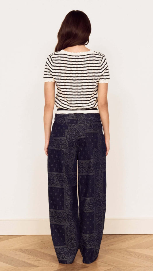 Back view of a woman wearing the Cream Stripe Cotton Pointelle Knit Top with stylish patterned pants.