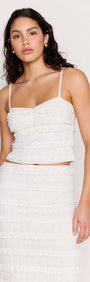 Model wearing the Cream Textured Lace Cropped Cami Top featuring slim straps and tiered lace detailing.