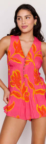 Model showcasing the ELODIE SLEEVELESS PLAYSUIT in vibrant pink with floral patterns.