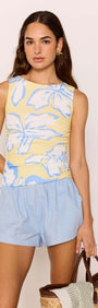 Model wearing Yellow & Blue Floral Ruched Mesh Top with light blue shorts, holding a tote bag, in a pastel floral print.