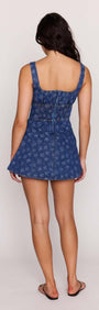 Back view of a model wearing the Floral Denim Mini Dress with a flared skirt and adjustable straps.