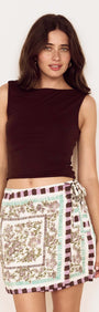 Model wearing Floral Scarf Print Wrap Mini Skirt with a black top, showcasing its floral design and wrap style.