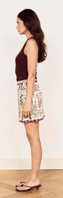 Model showcasing the Floral Scarf Print Wrap Mini Skirt from a side view, highlighting its stylish design and wrap silhouette.