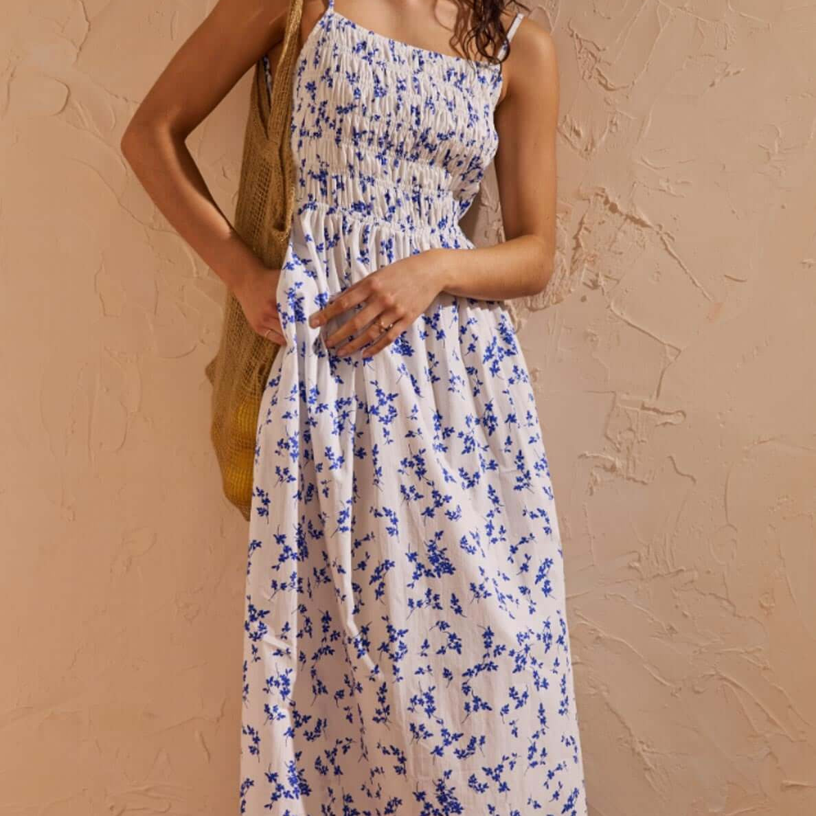 Blue Floral Cotton Backless Midi Dress displayed on a model with a soft ditzy floral print in a warm setting.