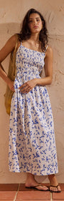 Blue Floral Cotton Backless Midi Dress displayed on a model with a soft ditzy floral print in a warm setting.